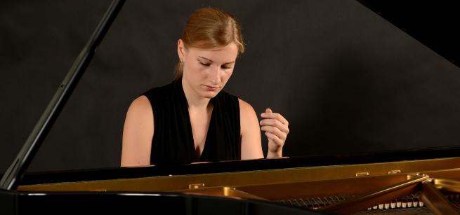 headshot of eva with piano