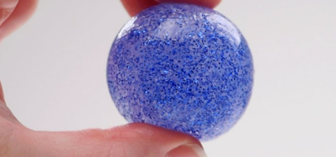 Image of a finished bouncy ball, held in a hand.