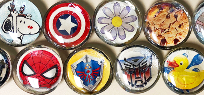 round glass magnets decorated with various characters and pictures