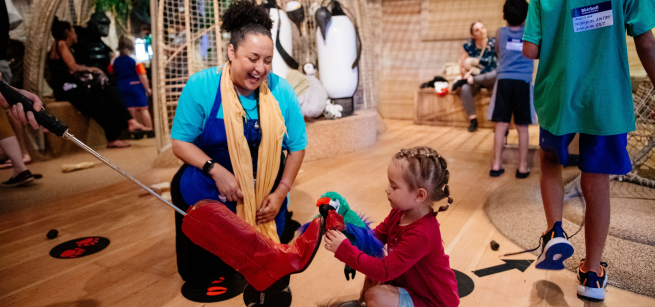Child and educator interacting with puppets at the Skirball Cultural Center’s Noah’s Ark Exhibit.