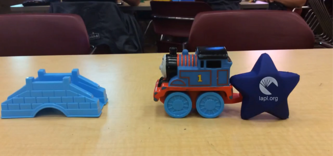 A toy bridge, a toy train, and a stress ball shaped like a star