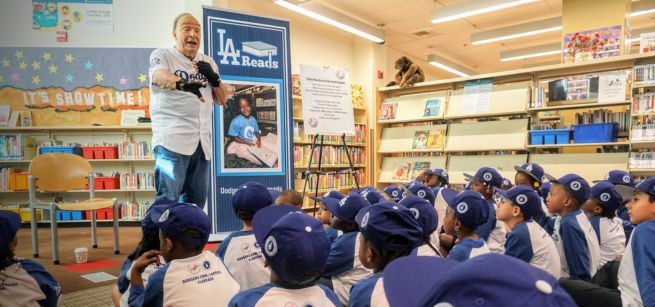 Dodgers alumni speaks to a room full of children in Dodgers baseball caps.