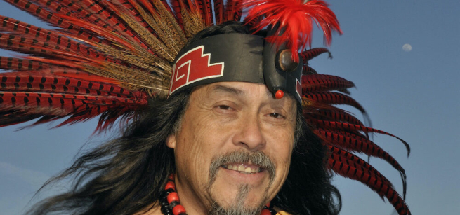 Musician and educator Martin Espino is pictured wearing a feathered headdress.