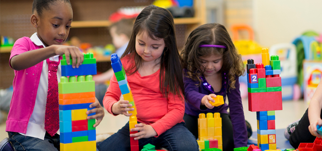 Three children playing with building blocks.