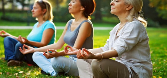 3 women meditating outdoors