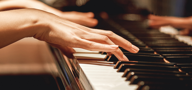 Close up of hands playing piano