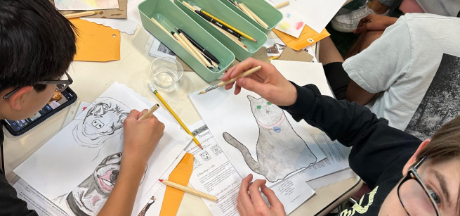 Group of teens at a table creating art with water color pencils.