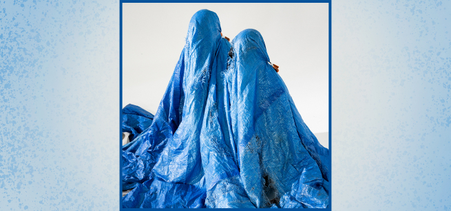 people under a large blue plastic tarp