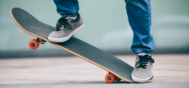 photo of someone's legs about to jump on a skateboard 