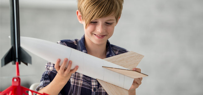 child-holding-paper-rocket