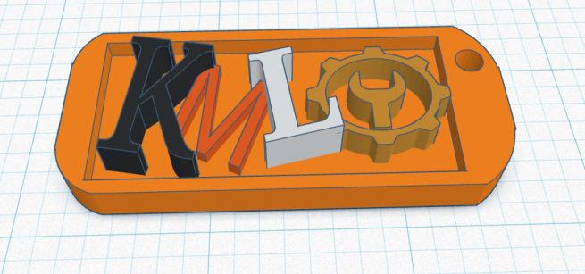 A keychain with text that says "KML" in computer 3D space