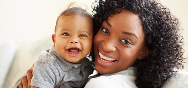 mother holding a smiling baby