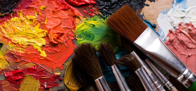 a canvas with paint and several brushes