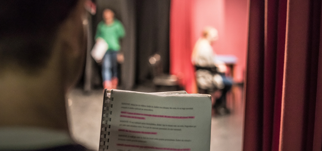 person holding a script in a theater setting
