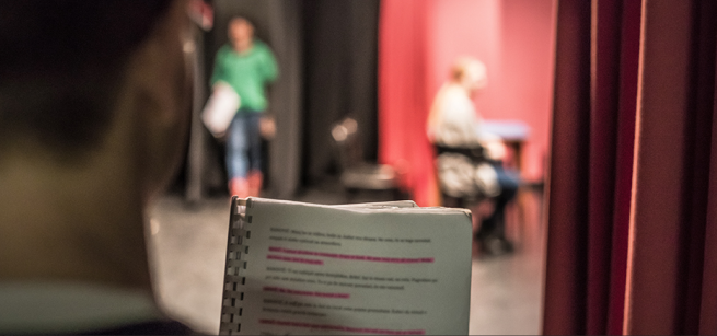 person with highlighted passages in a play with two other people