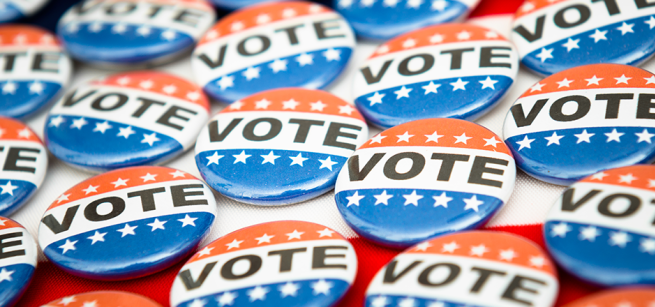 Red, white and blue buttons on a table that say "VOTE"