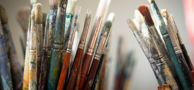 various paint brushes standing up in a container