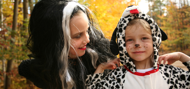 two children dressed in costumes; one as a witch and one as a dalmation