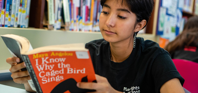 teen reading at the library