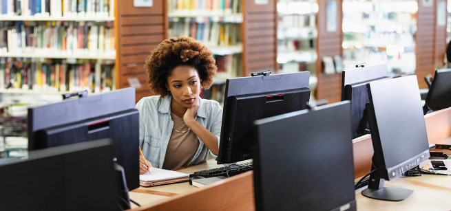 women looking at a computer in the library
