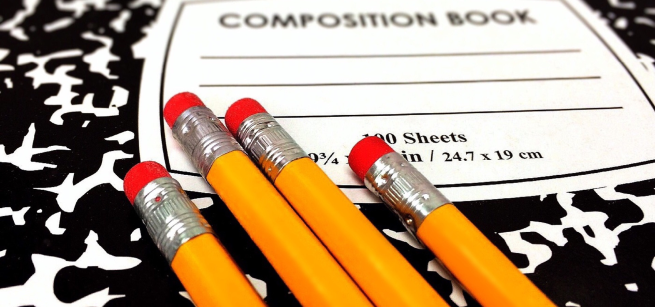 Composition notebook with four pencils on top