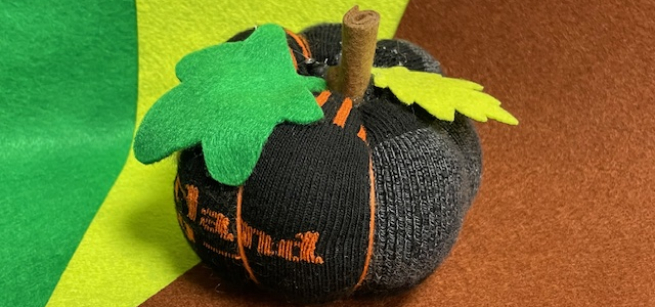 A mini pumpkin made out of an upcycled sock and felt.