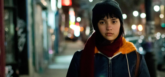 Actress Imajyn Cardinal as Fern stands on a city street dressed for cold weather