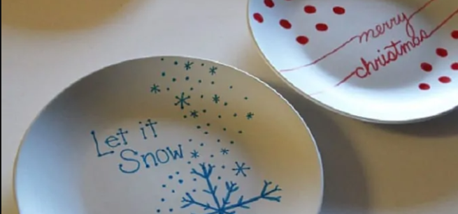 plates decorated with sharpie one saying "Let it Snow" and another saying Merry Christmas