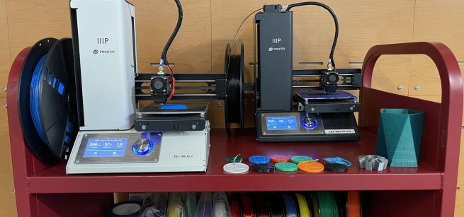 3D printers and colorful materials on a red book trolley