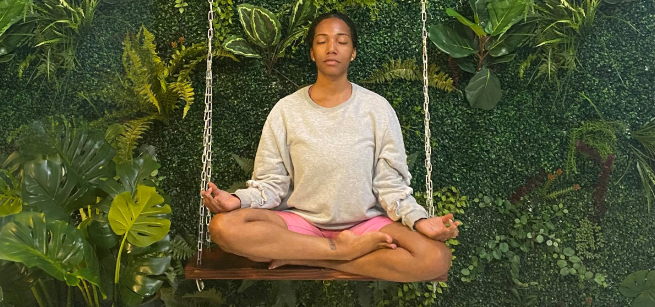 Aija Munns in a lotus pose against a background of plants
