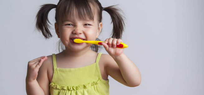 child brushing her teeth