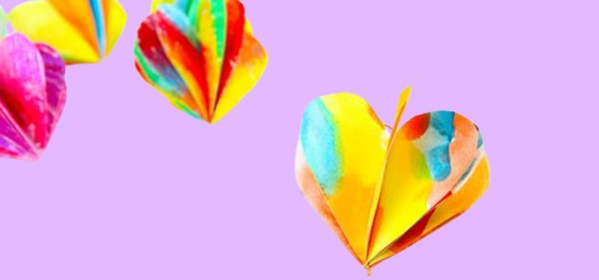 Multicolored 3D paper hearts on a pink background. 