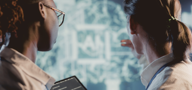 Two people looking at glowing image with Ai inside of a square