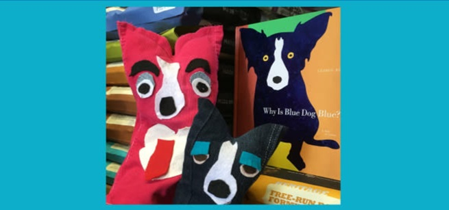 two handmade dog puppets and a book