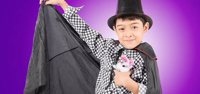 A child in magician's garb gestures dramatically.