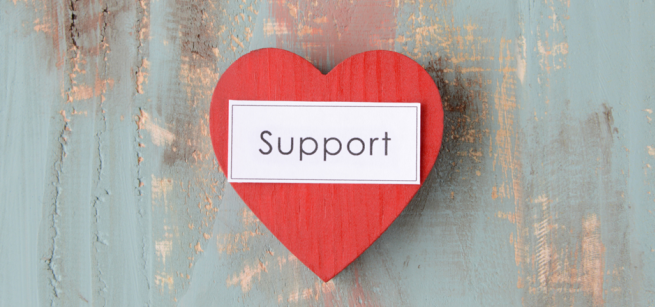 red heart with the word support written in black text