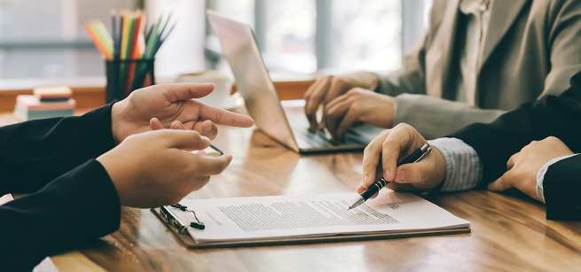 Peoples hands reviewing a legal document