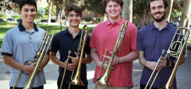 four men holding trombones