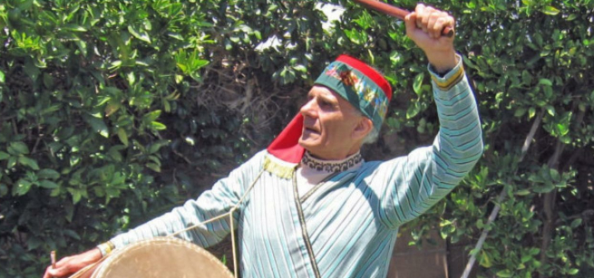 Dance instructor Tom Bozigian in Armenian costume with drum instrument