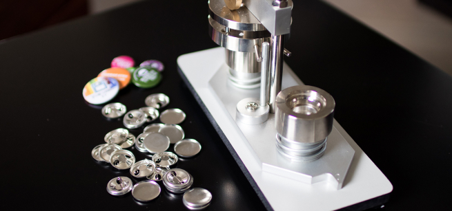 Button maker on a table with buttons around it.
