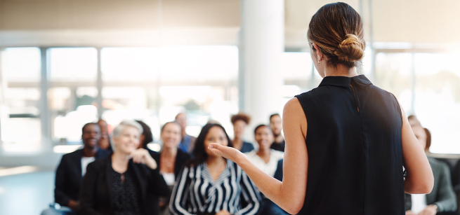 A woman gestures as she addresses a small group