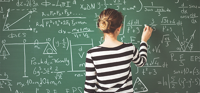 Woman doing math on a green chalkboard