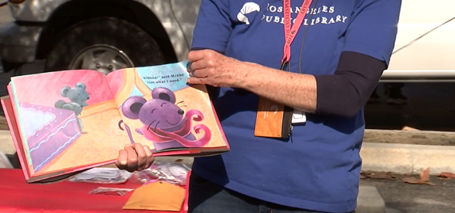 Staff member in blue shirt displaying book and turning pages