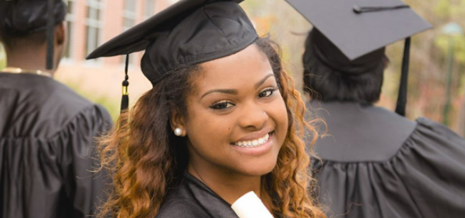 graduate in cap and gown, holding a diploma
