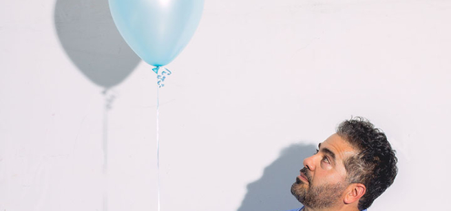 man looks up at balloon
