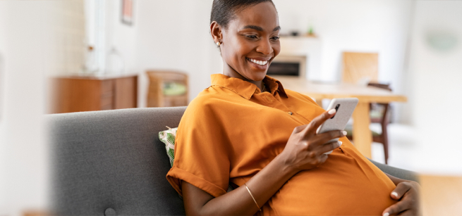 pregnant woman smiling in an orange blouse