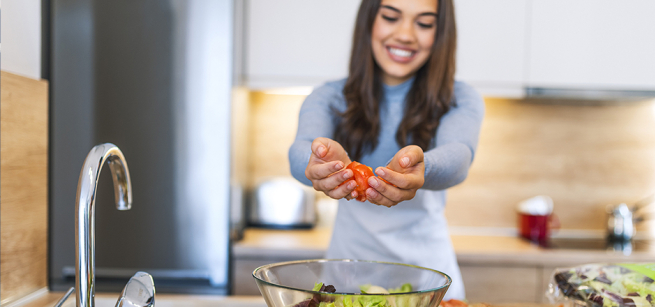 Girl making a meal in a kitchen. 