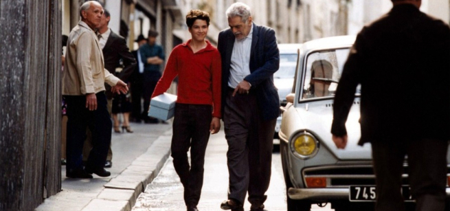 teen and older man walking down the street smiling and talking