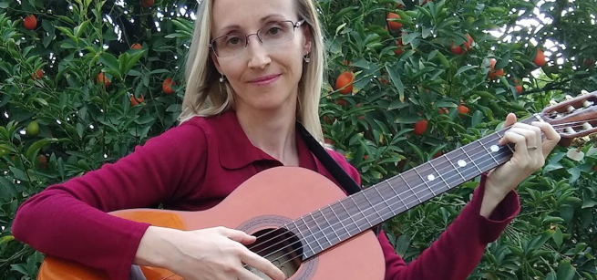 Natalya playing a guitar