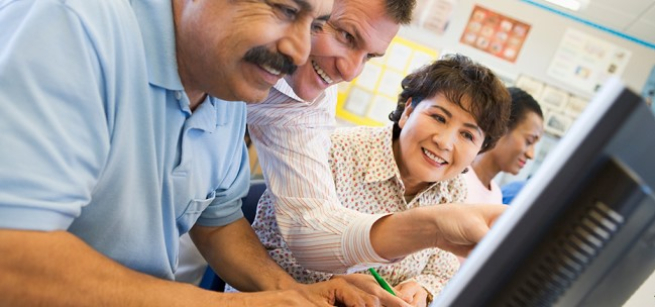 three people looking at a computer screen